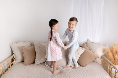 Pink Heart Nightgown for girls; two kids in sleepwear on a bed, pink heart-print nightgown and blue dotted pajamas.