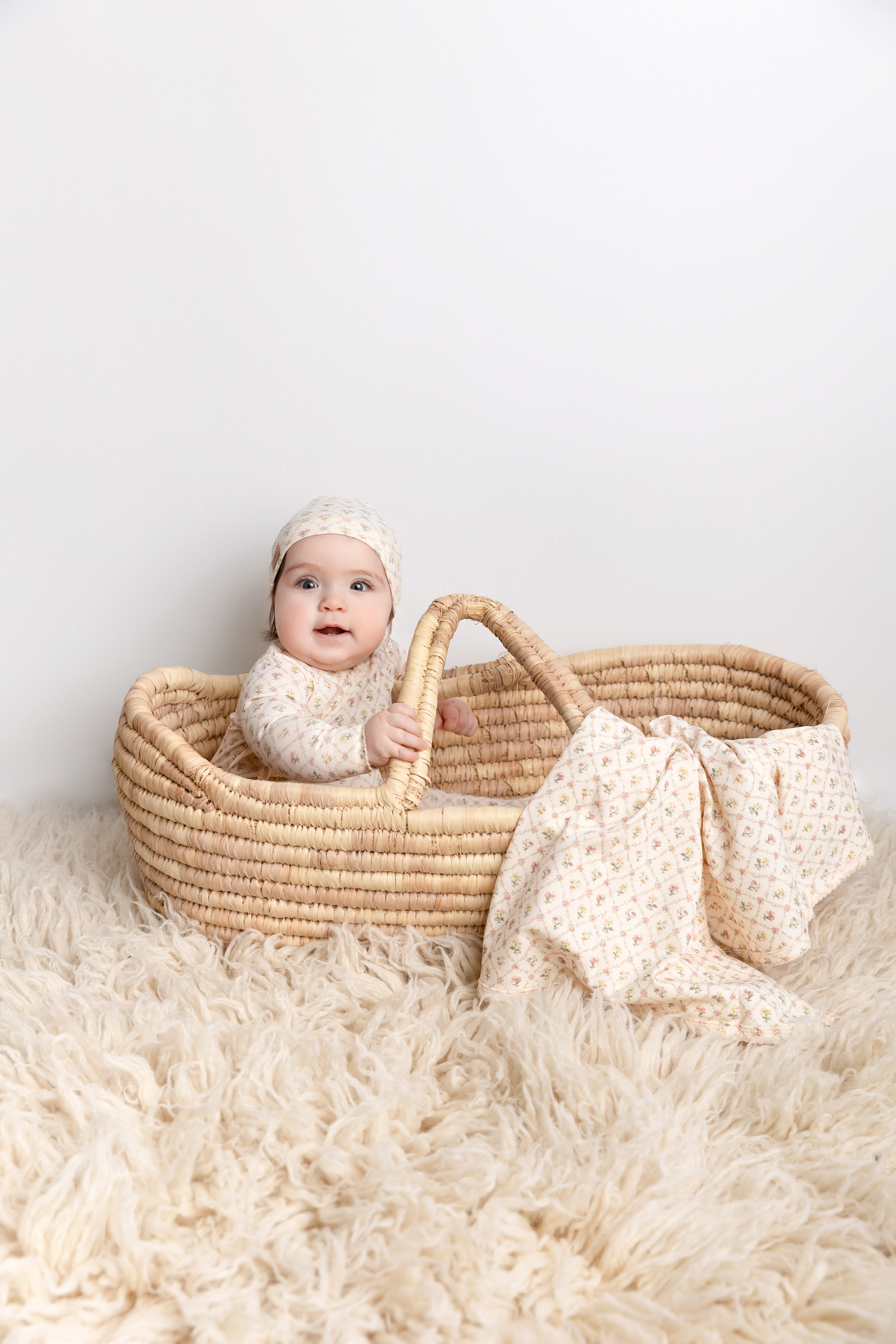 Flower Garden Stretchy girls stretchies in cream lattice floral print; baby sits in a woven basket with matching hat.