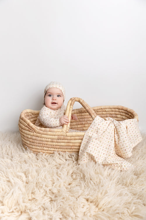Flower Garden Stretchy girls stretchies in cream lattice floral print; baby sits in a woven basket with matching hat.