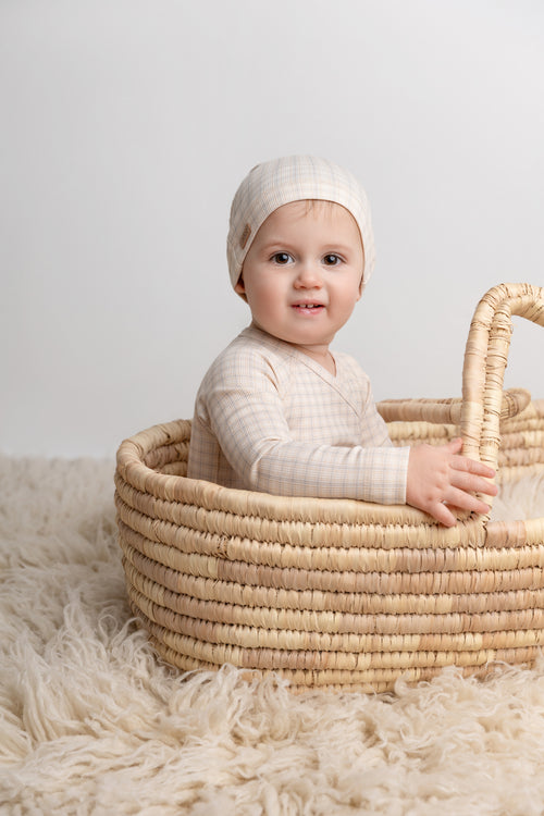 Oatmeal Grid Stretchy Boys Stretchies by Adee, beige grid-knit jumpsuit with beanie worn by baby in a basket